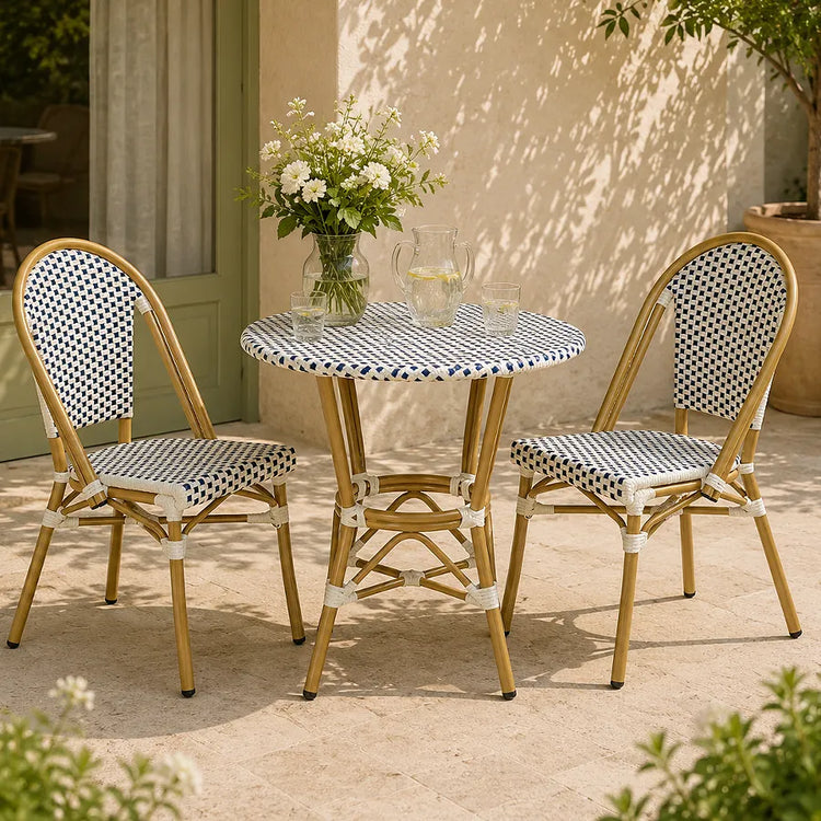 Rattan bistro set with two woven chairs and a round table on a sunny courtyard